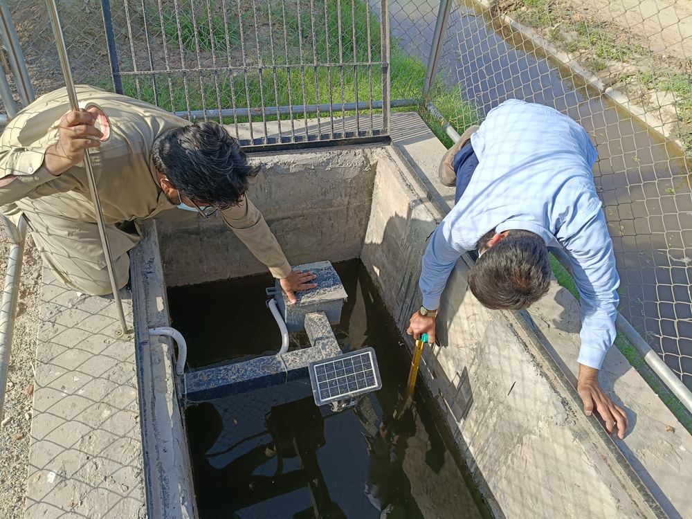 Home xWIT team installing a solar powered water level sensor inside a gauge well